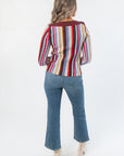 Back view of Steve Madden Burgundy Serra Stripe Sweater highlighting vertical stripe design and ribbed hem, styled with denim and heeled boots.