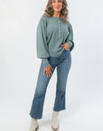 Free People Jade Ash Quinn Knit Thermal – Oversized balloon sleeve henley top in jade ash, styled with denim jeans and white ankle boots.