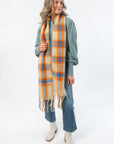 Free People Highland Plaid Embellished Scarf styled with fall outfit. Lightweight tartan scarf in orange, blue, and beige for seasonal layering.