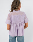 Back view of Lacy Lavender Mesh Babydoll Blouse highlighting pleated design and sheer mesh panel for a feminine spring look.