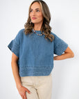 Indigo Daydream Chambray Denim Top | Short Sleeve Crop Top with textured hem and sleeves, styled with beige pants for a casual chic look.