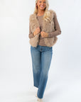 Boutique-style Fifth Avenue Taupe Faux Fur Vest paired with denim and ankle boots. Chic sleeveless outerwear perfect for holiday or wedding guest looks.