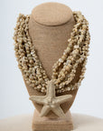 Beige starfish and seashell statement necklace with sandy pebble beads on display