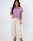 Wisteria Willow Short Sleeve Lilac Sweater paired with cream wide-leg pants and sandals, perfect lightweight top for spring and summer outfits.