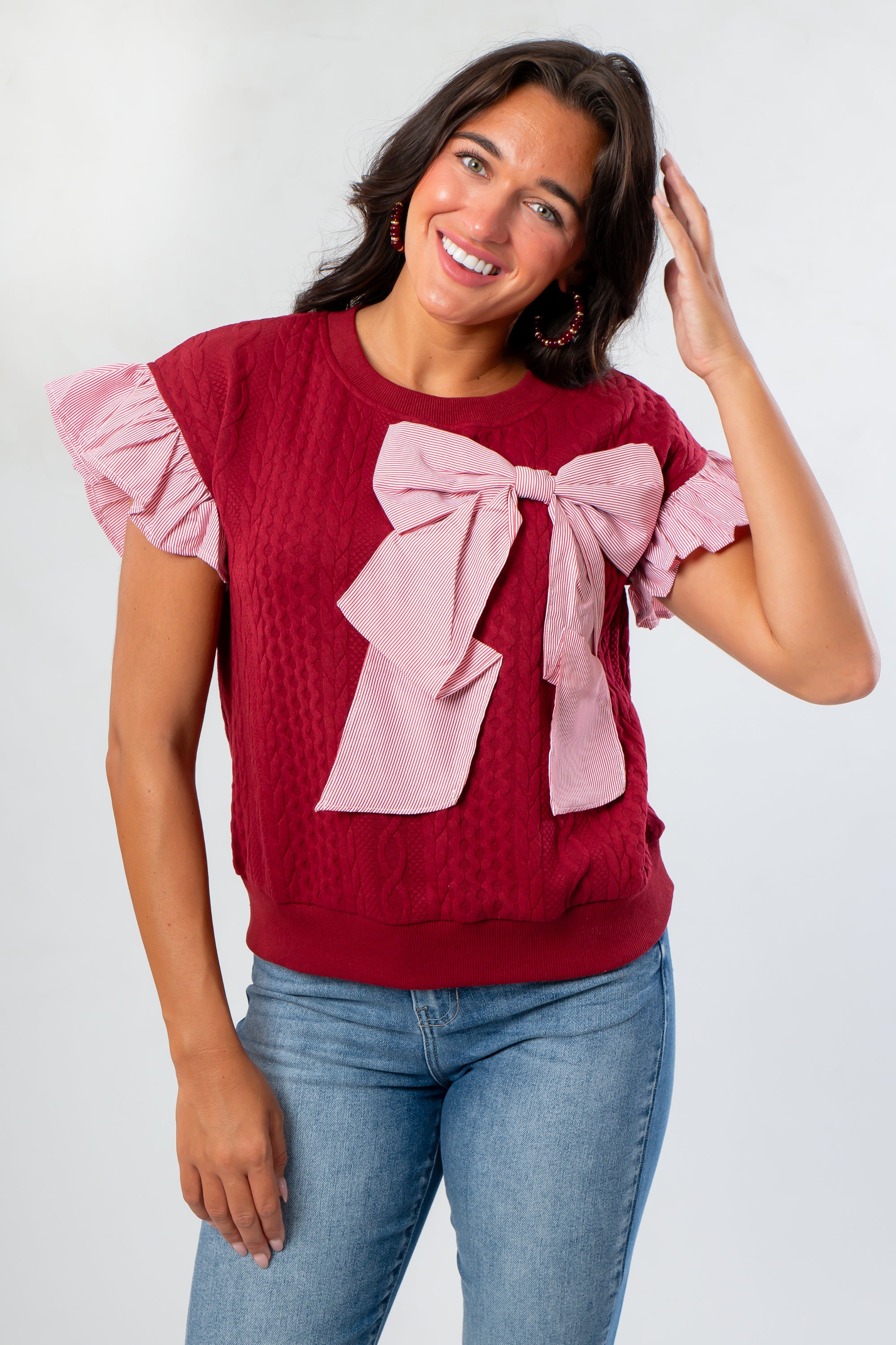 Red Burgundy Knit Top featuring a large pink bow and ruffled sleeves, perfect for gameday or holiday outfits with a soft, warm texture.