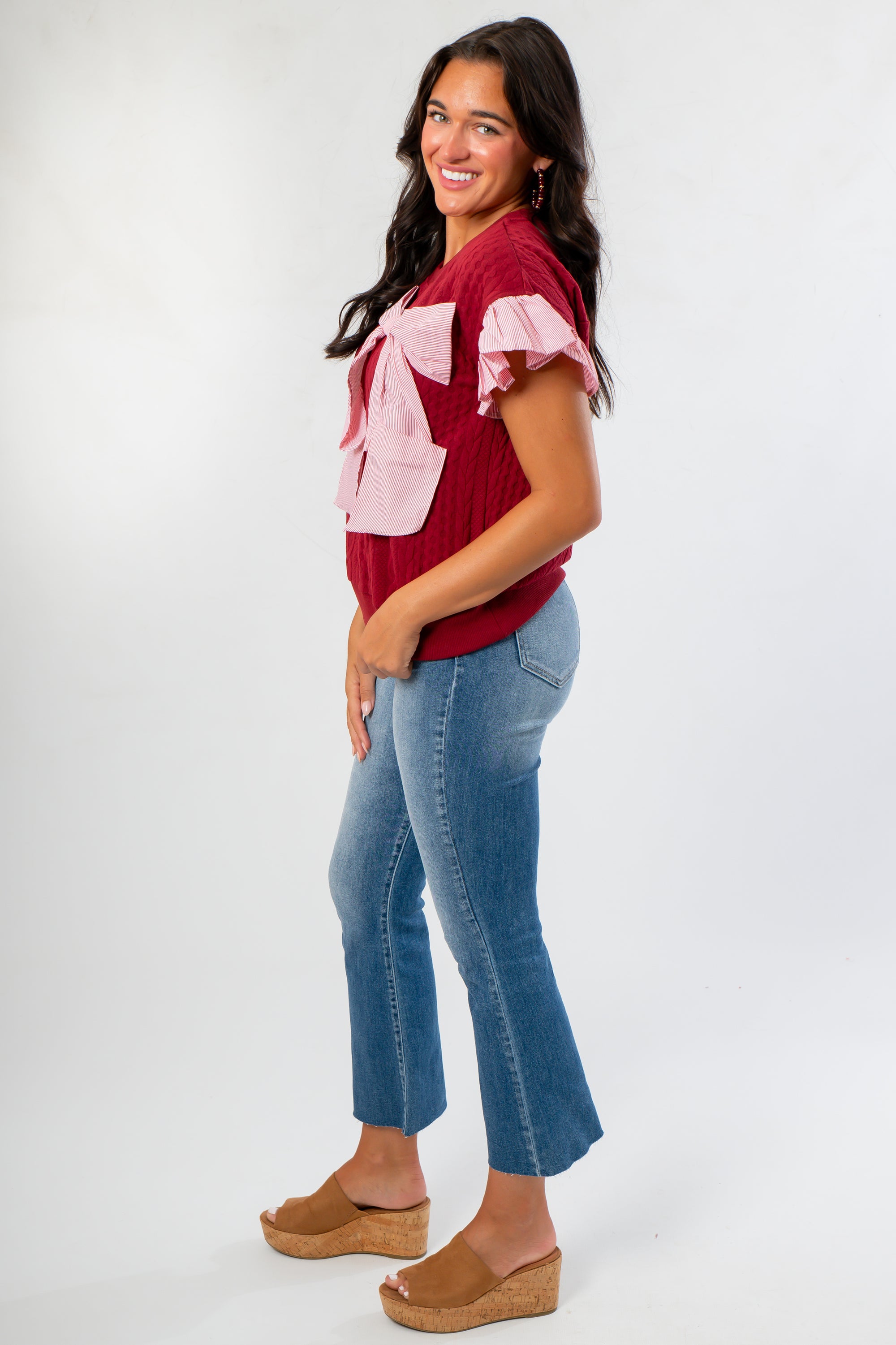 Side view of Burgundy Bow Cable Knit Top showing textured knit design and feminine pink bow, ideal for pre-fall and holiday styling.