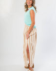 Side view of Tiffany Sleeveless Blue Ribbed Knit Top paired with a flowy striped skirt. A fall essential for layering or solo wear.