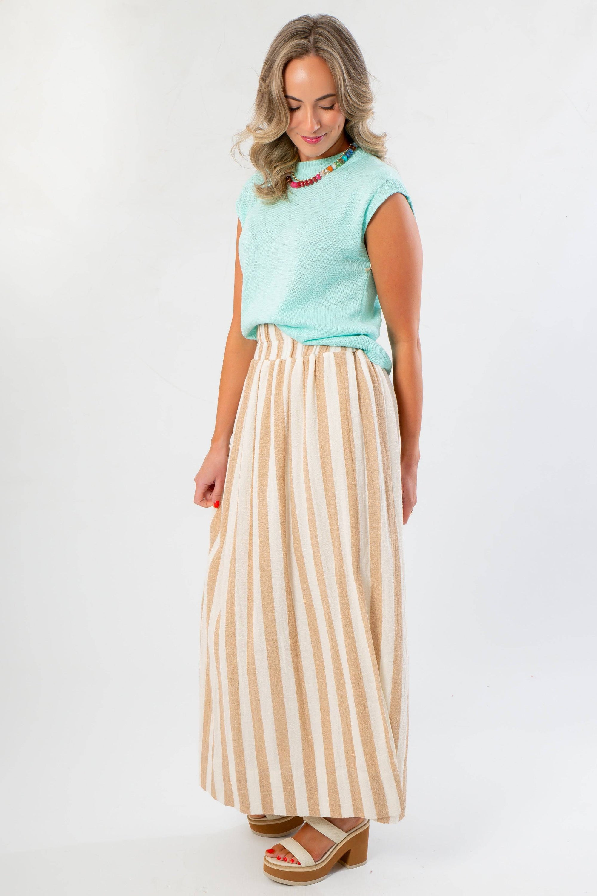 Tiffany Sleeveless Blue Ribbed Knit Top in a relaxed fit, shown with a neutral striped skirt. Ideal for pre-fall wardrobe updates.
