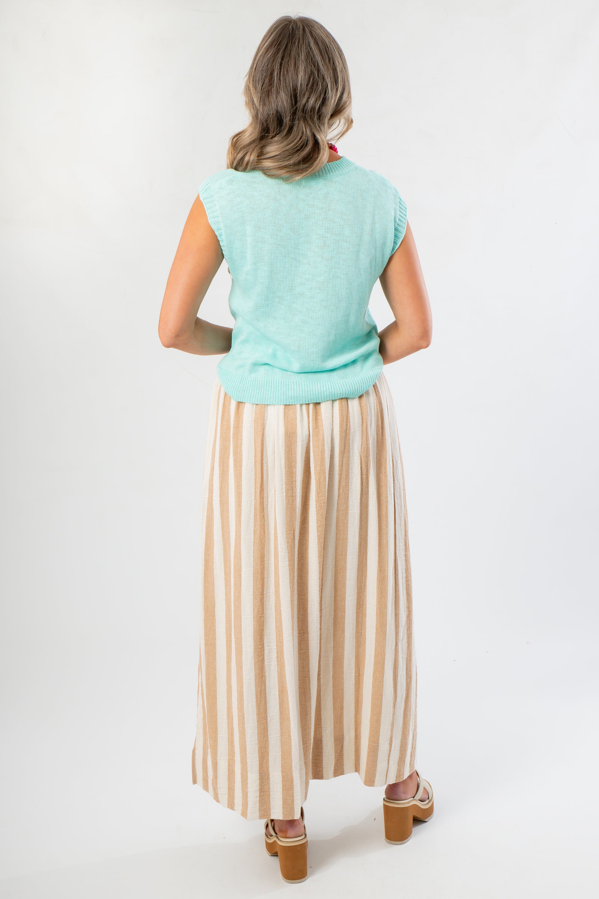 Back view of Tiffany Sleeveless Blue Ribbed Knit Top showcasing ribbed hem detail. A versatile lightweight sweater for fall.