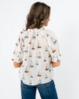 Back view of THML Sailboat Short Sleeve Blouse highlighting sailboat print and gathered neckline detail.