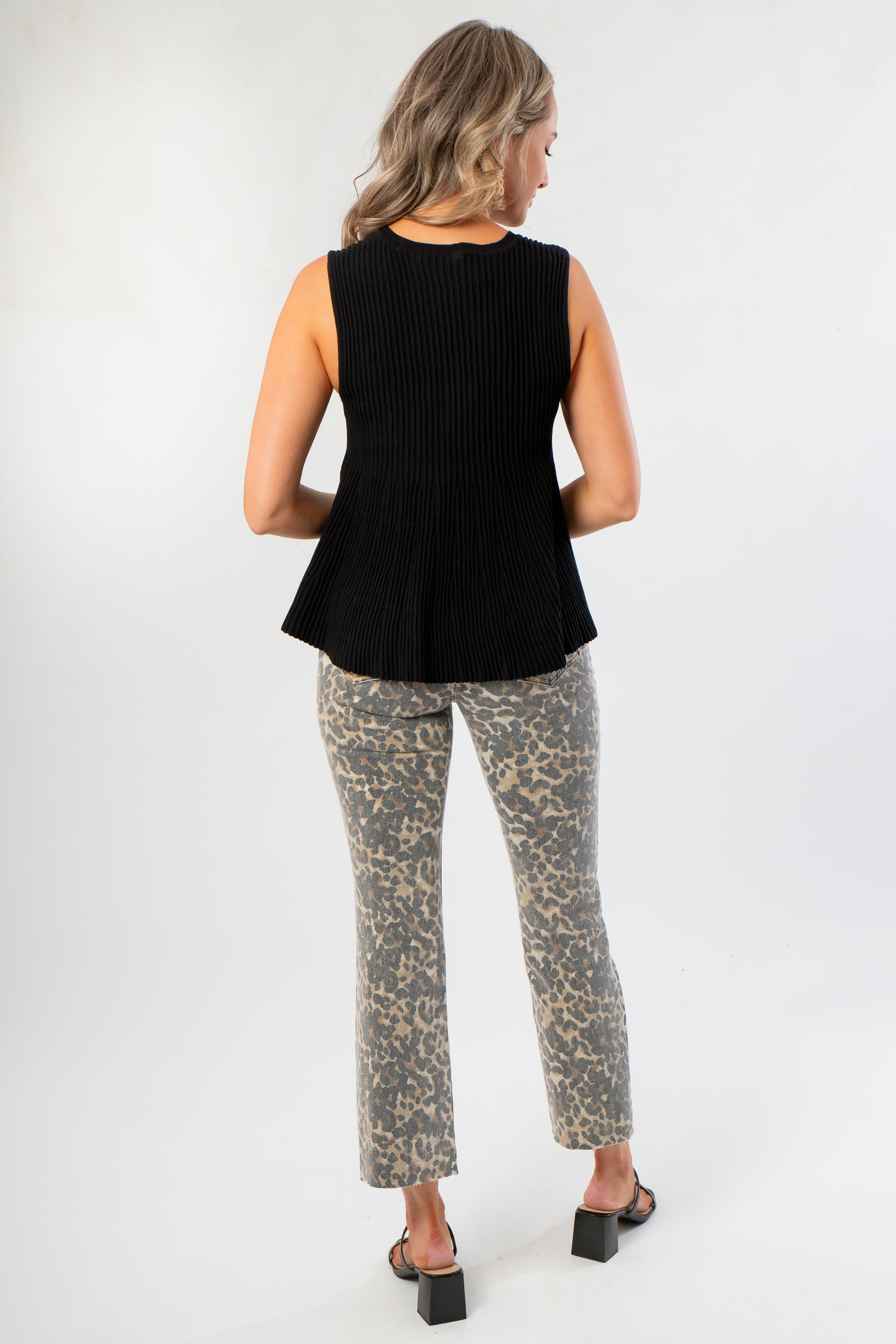 Back view of Black Flared Rib Knit Top showcasing its ribbed knit texture and flared hem, ideal for casual or dressy outfits.