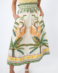 Model wearing tropical print midi skirt with yellow top, showing side pockets and vibrant pattern