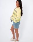 Side view of Country Club Stripe Knit Sweater showing relaxed fit and soft knit texture. Styled with frayed denim shorts for a casual look.