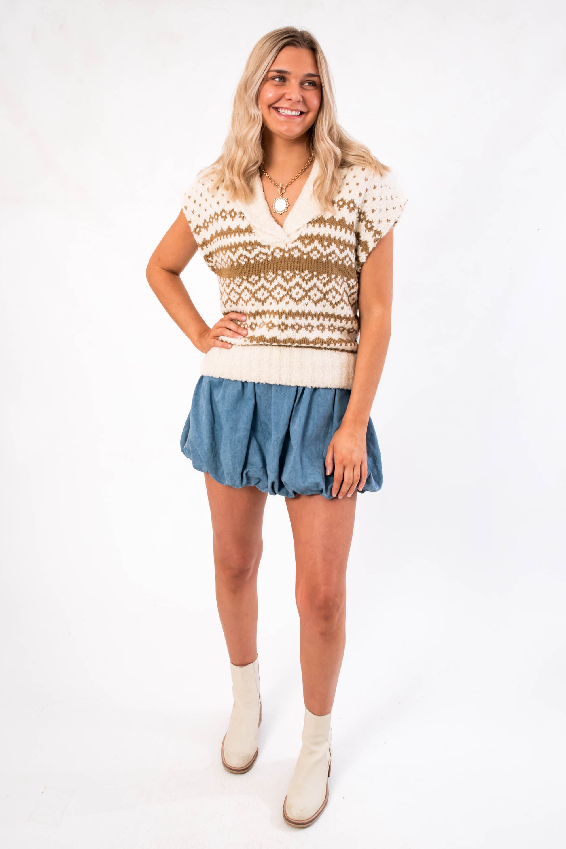 Front view of Steve Madden Multi Paulie Sweater Vest, a sleeveless knit top with neutral tones, paired with a denim-style mini skirt.