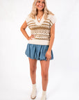 Front view of Steve Madden Multi Paulie Sweater Vest, a sleeveless knit top with neutral tones, paired with a denim-style mini skirt.