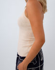 Tan knit halter top with shell trim paired with navy mini skirt with shell embroidery