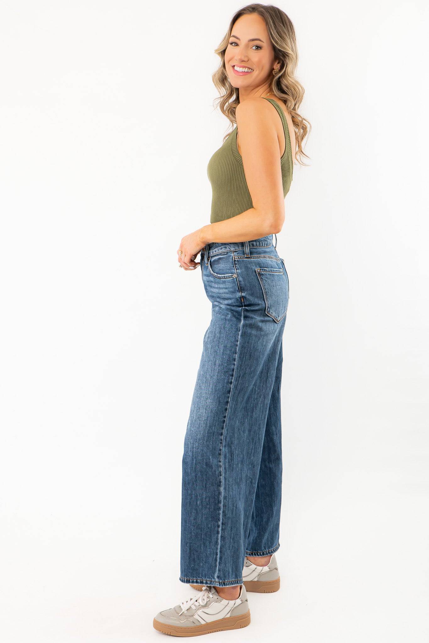 Olive Seamless Cropped Brami styled with high-waisted wide-leg jeans, showcasing a summer essential activewear top in a ribbed olive green fabric.