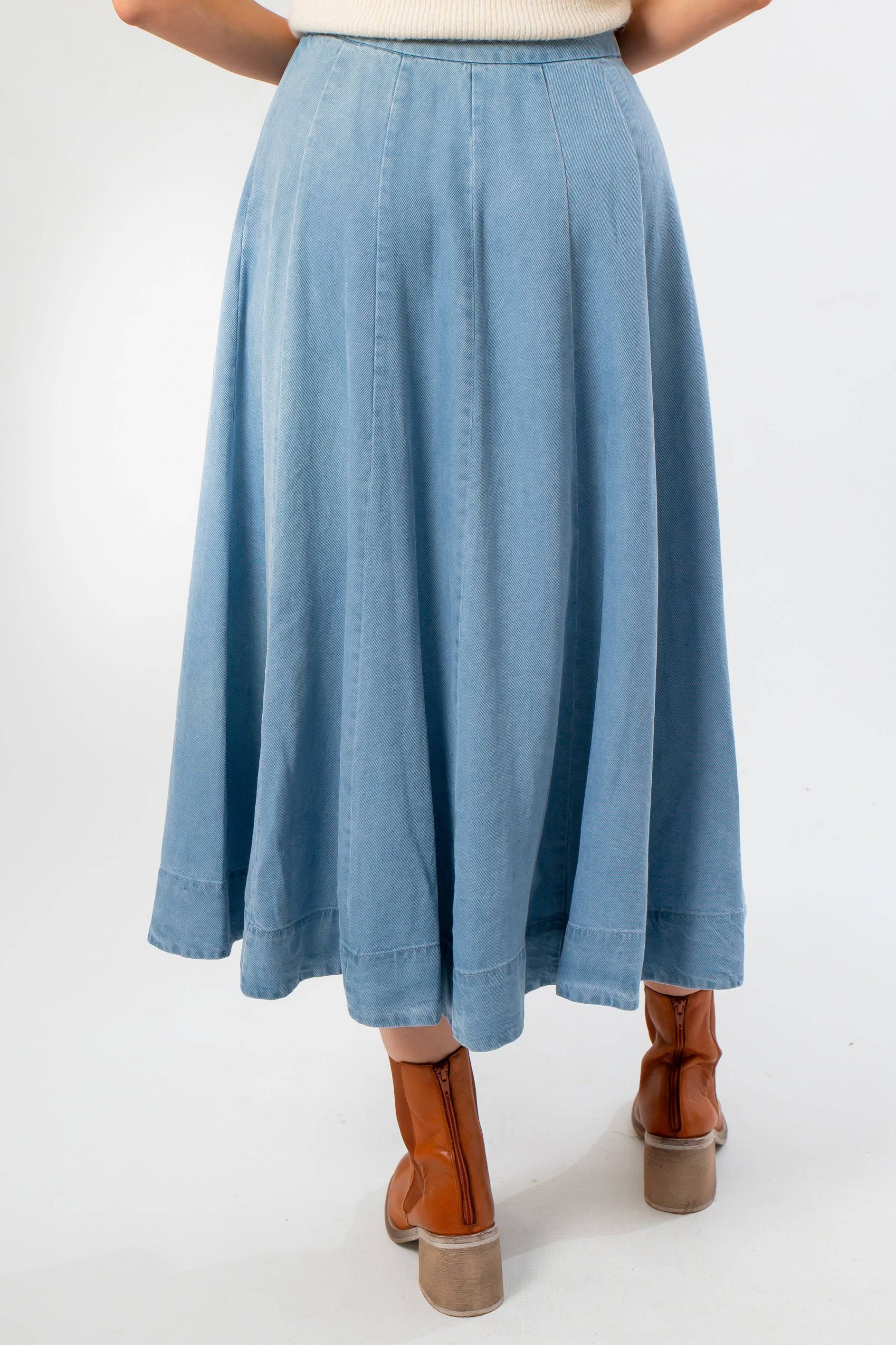 Back view of Washed Denim Paneled Midi Skirt highlighting the flared hem and structured panel seams for a graceful drape.