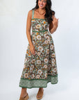 Front view of brown floral midi dress with pockets and green trim, ideal for casual fall outings and Thanksgiving gatherings.