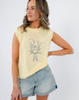 Close-up of sleeveless yellow sweater featuring a lobster embroidery. Lightweight knit top for summer vacations and brunch styling.