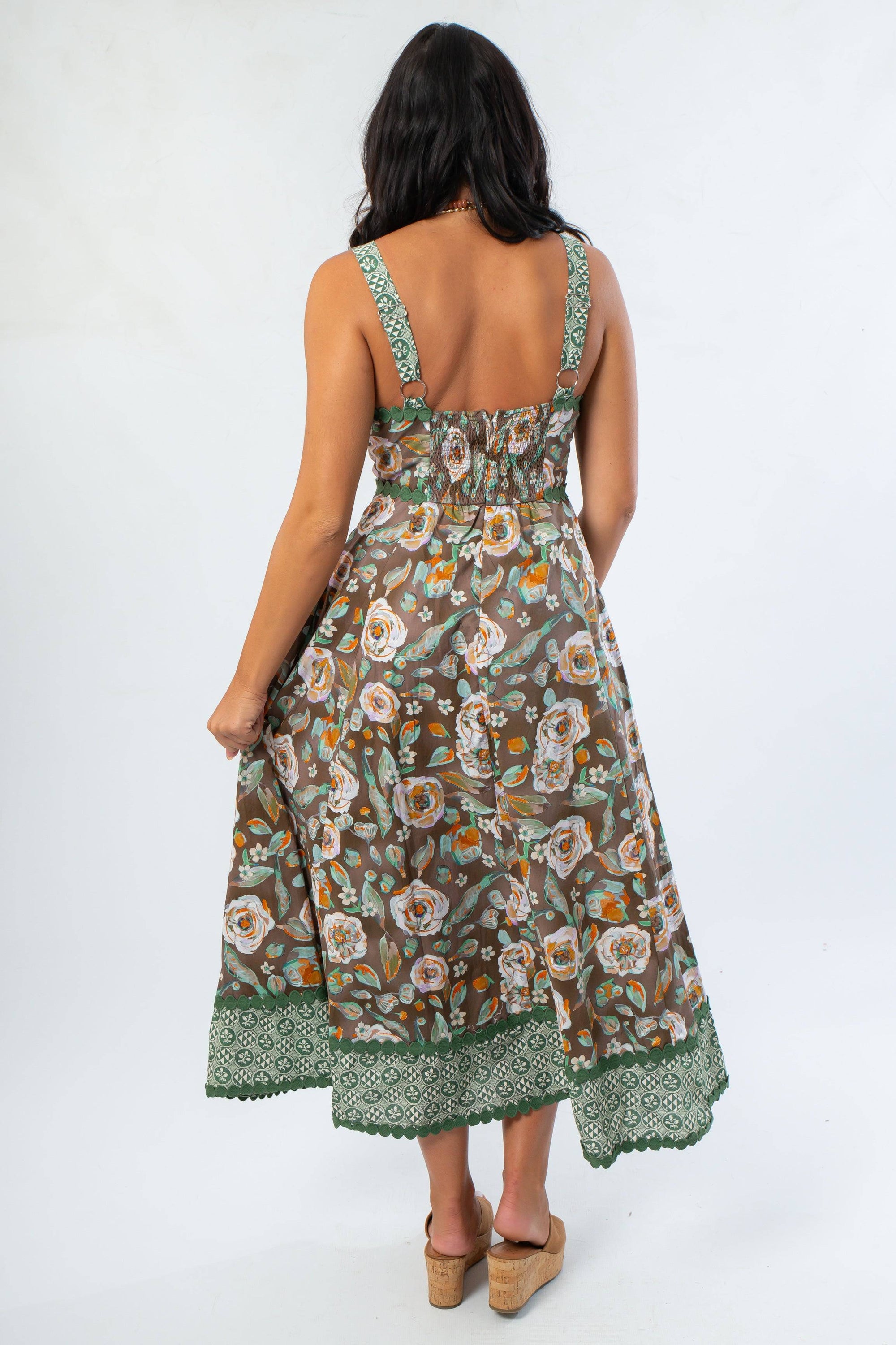 Back view of sleeveless brown floral midi dress showing smocked panel and flared silhouette for comfort and style.