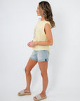 Side view of lobster embroidered sleeveless sweater in buttery yellow. A breathable knit top for effortless summer layering.