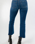 Back view of On The Daily Dark Wash Crop Flare Jeans showcasing flattering pocket placement and cropped flare cut.