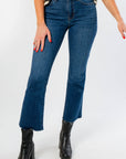 On The Daily Dark Wash Crop Flare Jeans with raw hem and high waist, styled with black boots for a trendy fall denim look.