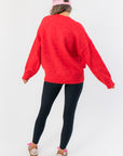 Back view of Candied Cherry Red Knit Sweater highlighting its oversized silhouette and ribbed hem, great for layering in cold weather.