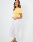 Side view of Lemon Drop Essential Short Sleeve Tee paired with wide-leg white pants and sandals, perfect for a relaxed summer outfit.