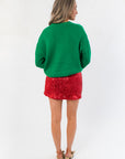Back view of green 'Merry' Christmas sweater highlighting ribbed knit texture and cozy holiday style for winter outfits.