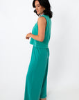 Back view of women in teal sleeveless lounge top and wide-leg pants