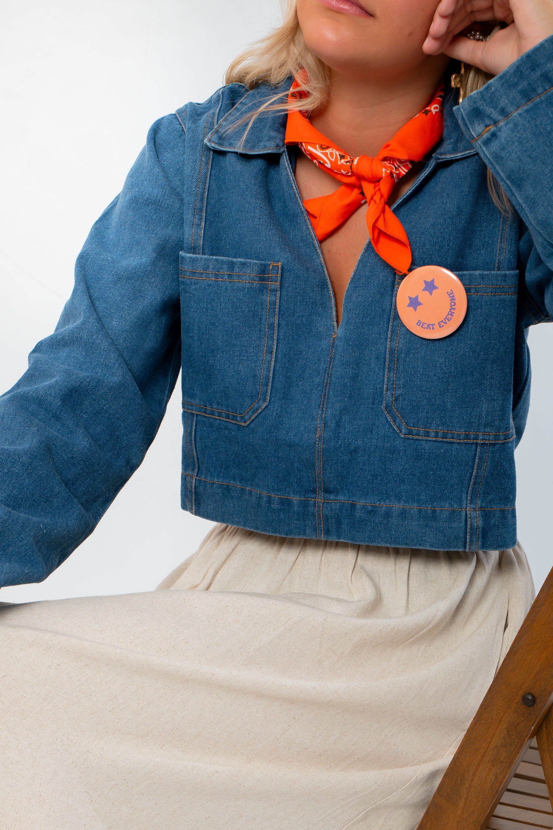 Close-up of Wide Open Denim Long Sleeve Top showing front pockets and collar detail. Lightweight denim perfect for gameday or casual wear.