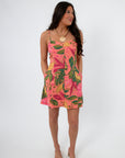 Cabana Nights Tropical Printed Mini Dress featuring vibrant tropical leaf print, sleeveless design, and flared mini hem for summer wear.