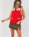 Front view of Clara Collared Knit Sweater Vest featuring red knit fabric with cream bow details and front pockets, ideal for holiday outfits.