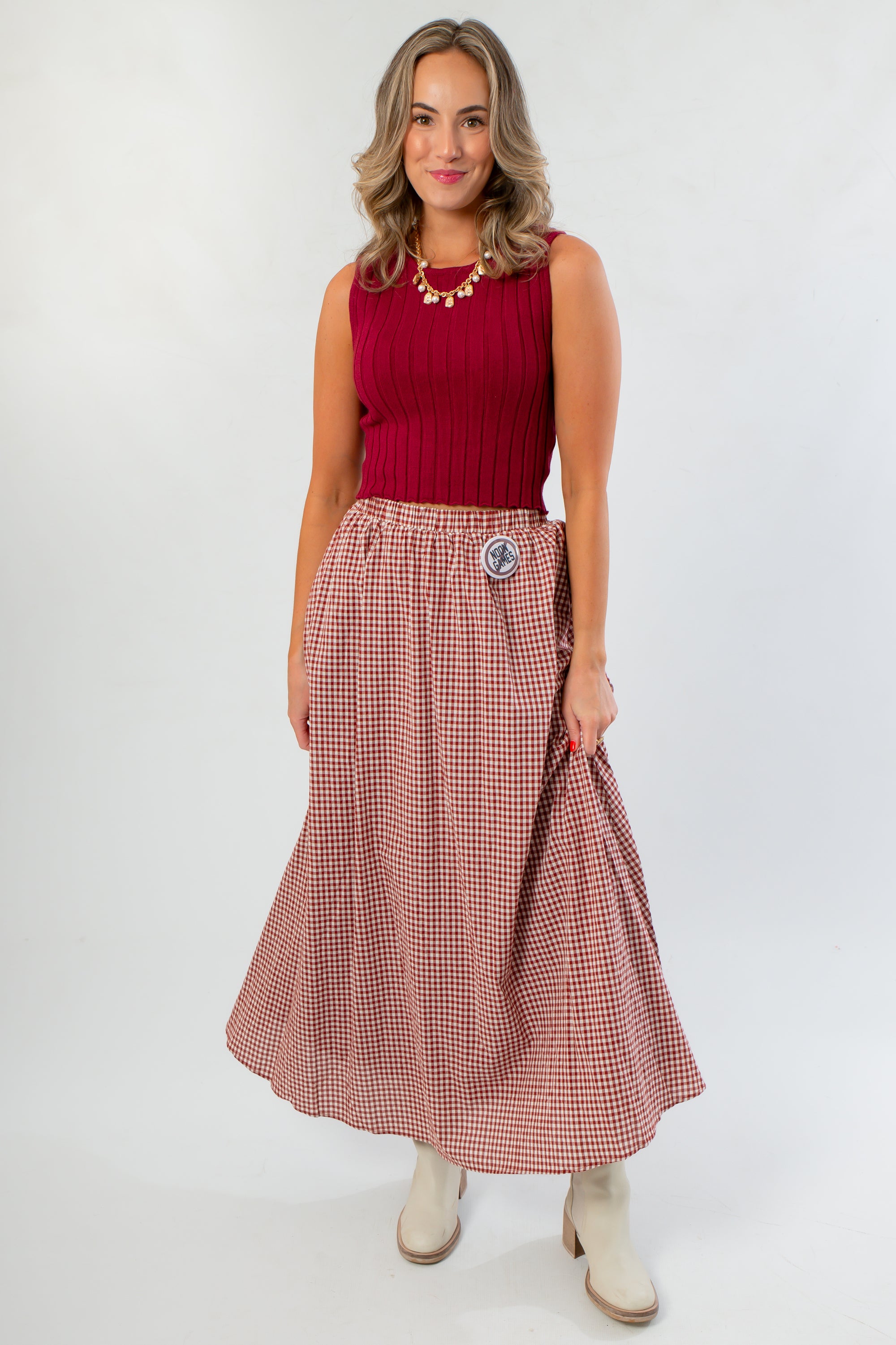 Versatile Wine & Dine Rib Sleeveless Sweater paired with a checkered maxi skirt, perfect for gameday or casual fall outings.