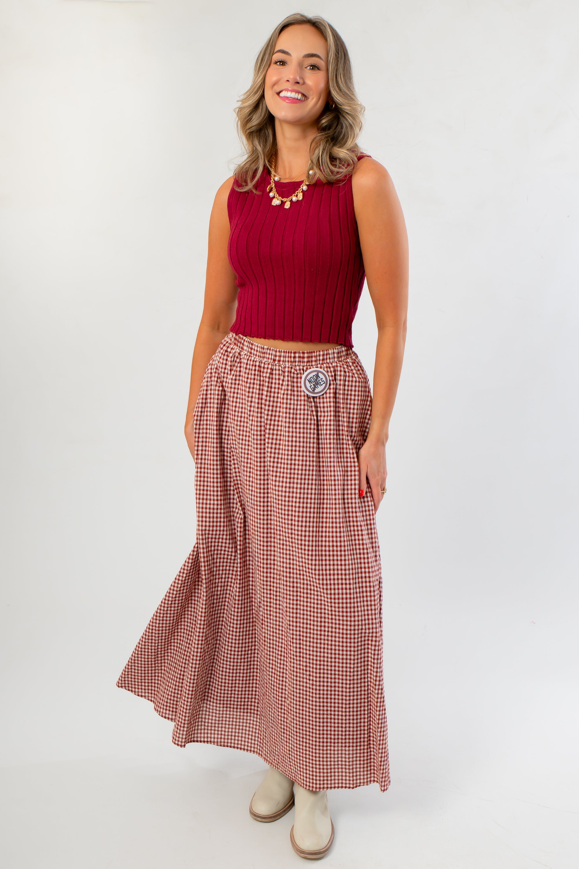 Wine & Dine Rib Sleeveless Sweater styled with a flowy gingham skirt, ideal for layering or wearing solo in transitional weather.
