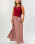 Wine & Dine Rib Sleeveless Sweater styled with a flowy gingham skirt, ideal for layering or wearing solo in transitional weather.