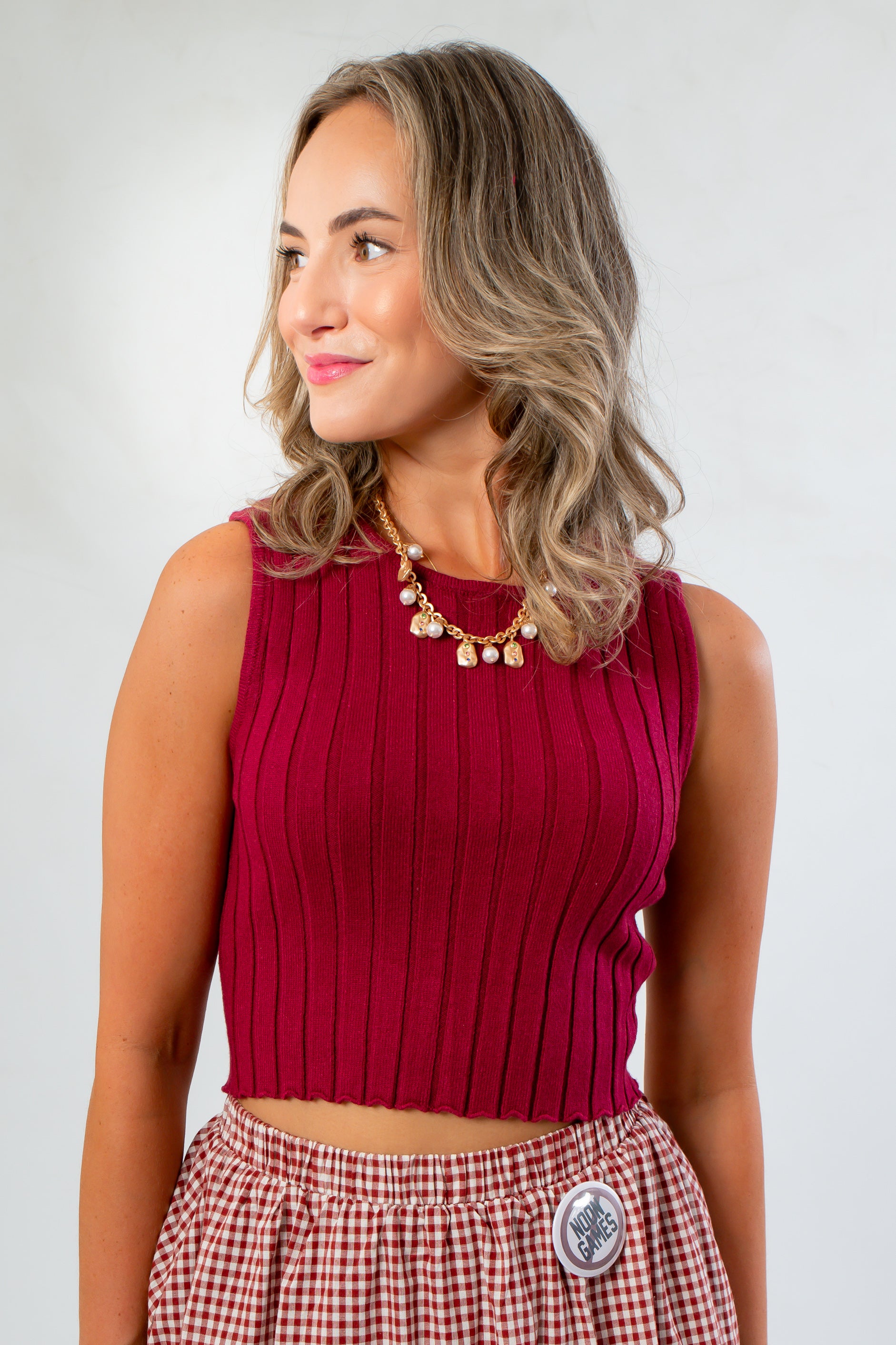 Wine & Dine Sleeveless Sweater in ribbed knit with a flattering fit, styled with a gingham skirt for a chic fall-ready look.