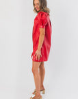 Side view of Sugarplum Showgirl Red Faux Leather Mini Dress showcasing its A-line cut and puff sleeve design for a bold, modern holiday outfit.