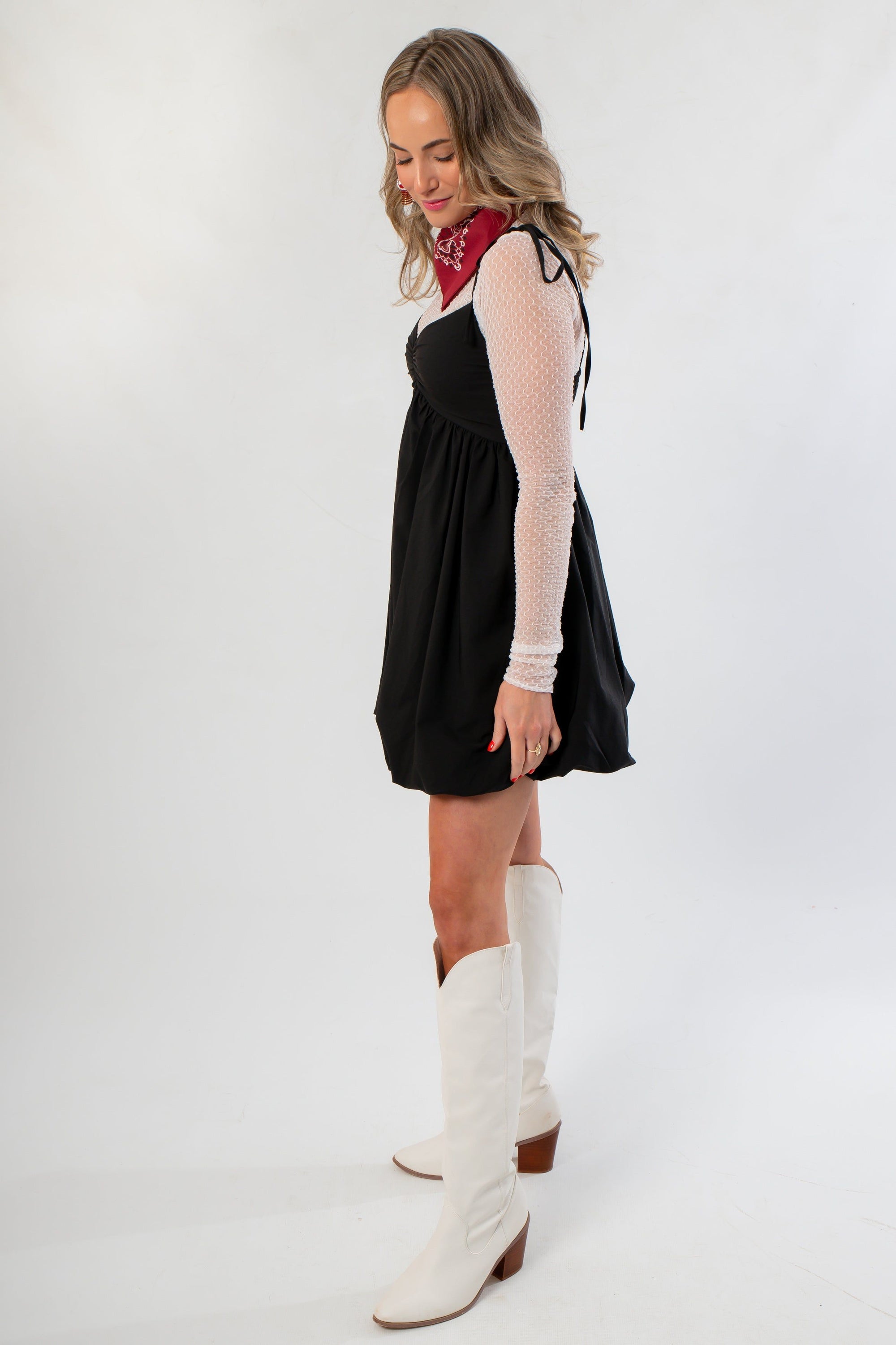 Side view of Black Bubble Hem Mini Dress showing flared silhouette and mesh sleeve detail, perfect for chic and playful occasions.