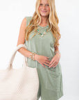 Soak Up the Sun Sage Green Tank Romper with front pockets, styled with a woven tote and layered jewelry for a breezy summer look.