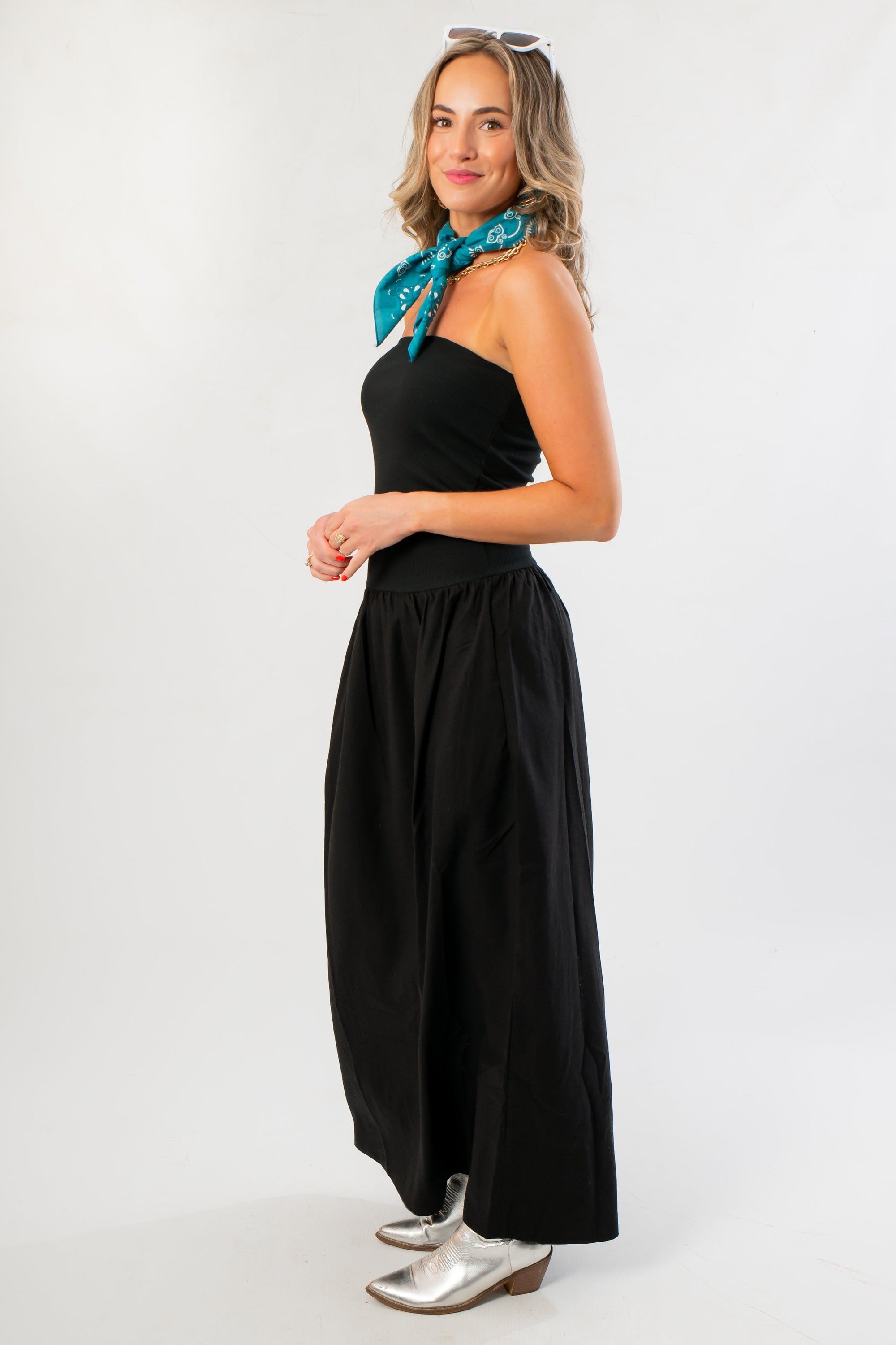 Elegant black strapless linen midi dress with flowy silhouette, styled for casual wear with silver boots and teal scarf from the WM collection.