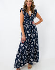 Back view of navy seashell print maxi dress with bow tie and ruffle sleeves
