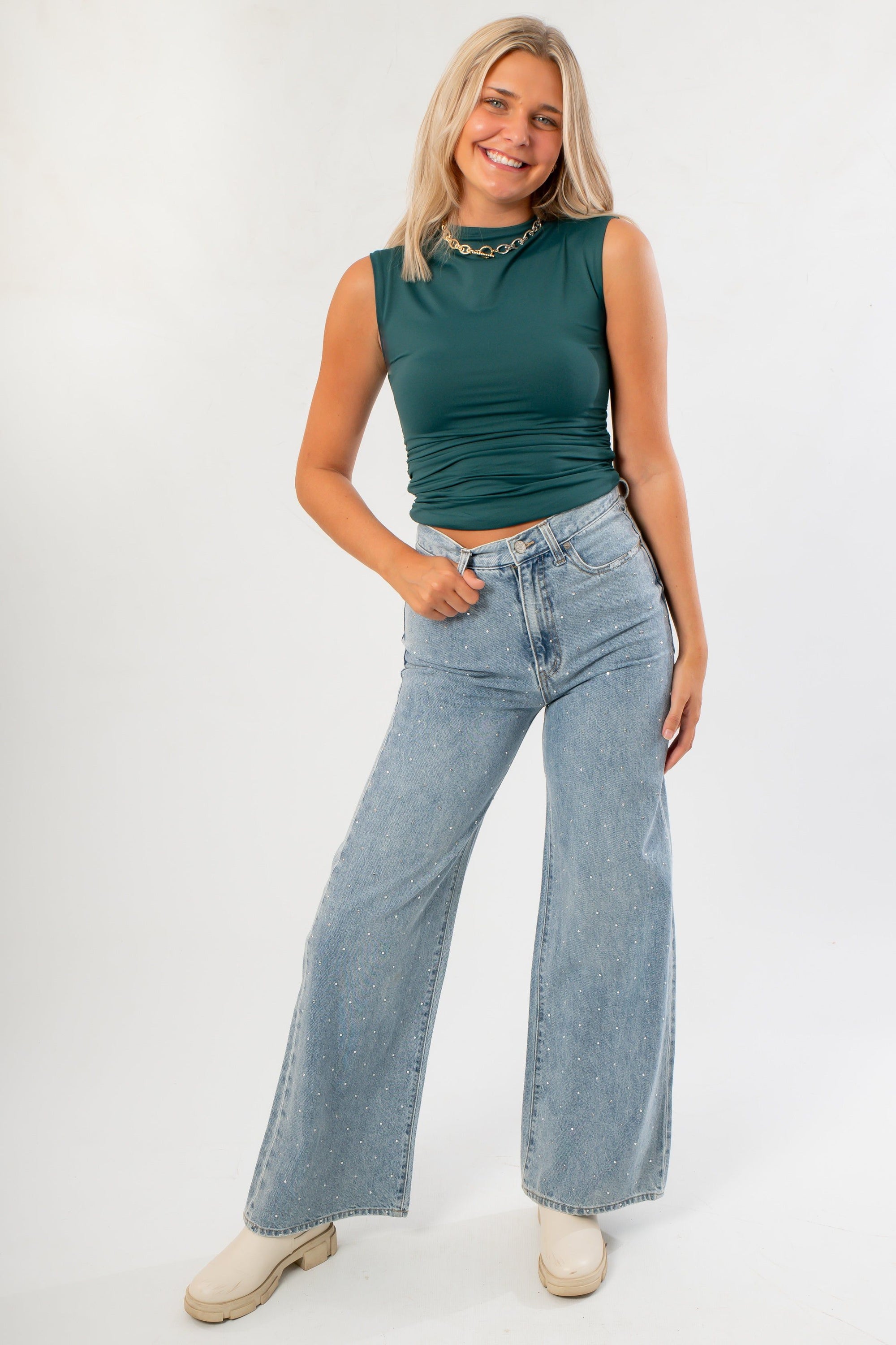 Luck Of The Draw Green Ruched Funnel Neck Tank paired with high-waisted light wash jeans. A chic sleeveless top perfect for layering or solo wear.