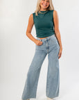 Luck Of The Draw Green Ruched Funnel Neck Tank paired with high-waisted light wash jeans. A chic sleeveless top perfect for layering or solo wear.