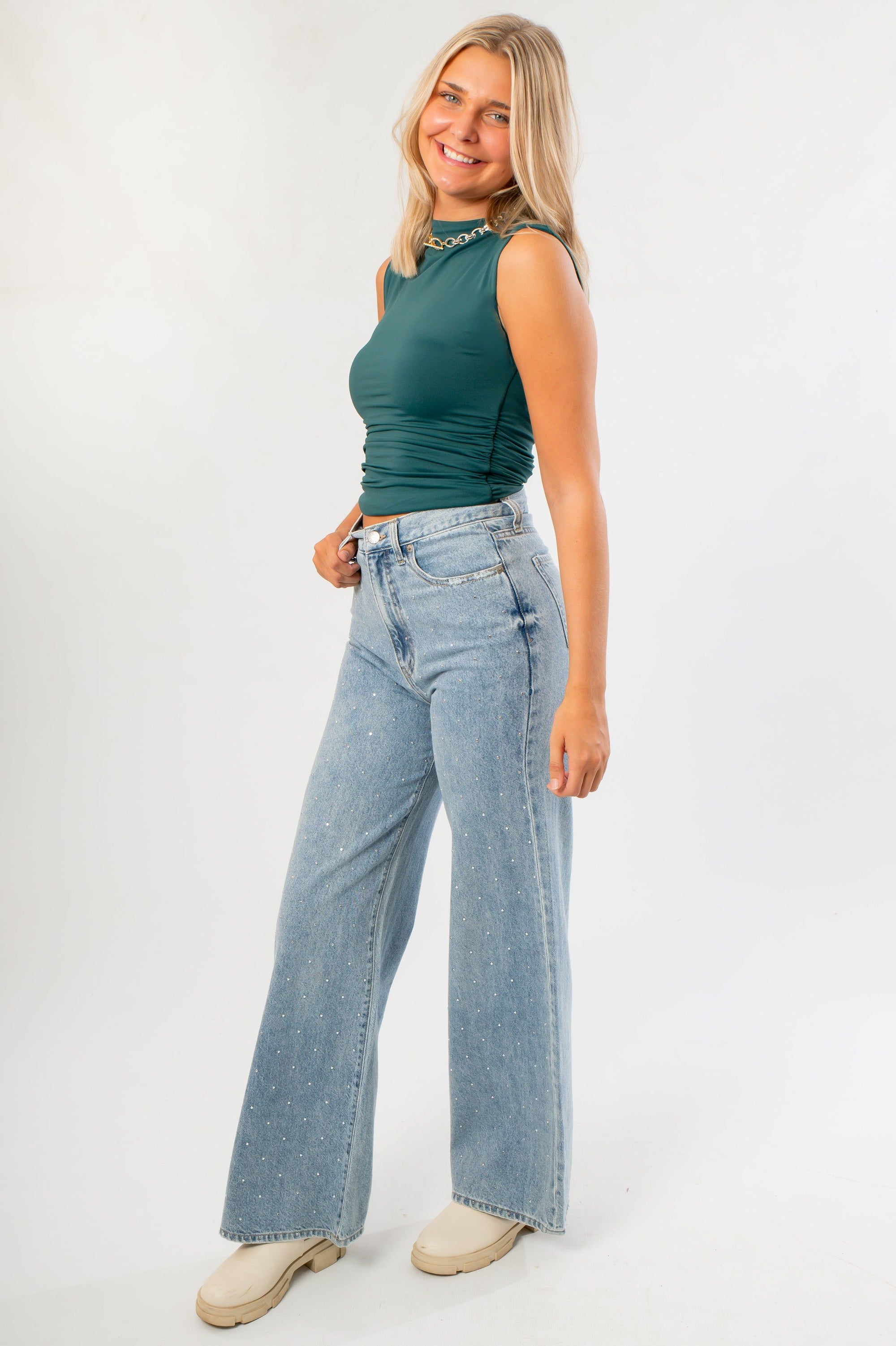 RD Style Funnel Neck Top in green with ruched detailing, styled with wide-leg denim. A sleeveless, sleek tank ideal for casual or work wear.
