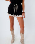 Black linen shorts with a cream scallop trim for a comfy and chic neutral game day outfit