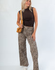Model wearing Luck Of The Draw Brown Ruched Funnel Neck Tank – Sleek Fit with wide-leg leopard pants, showcasing a chic sleeveless fall look.