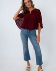 Burgundy bubble hem top with dramatic cape sleeves for fall workwear, dinner, date night, game day
